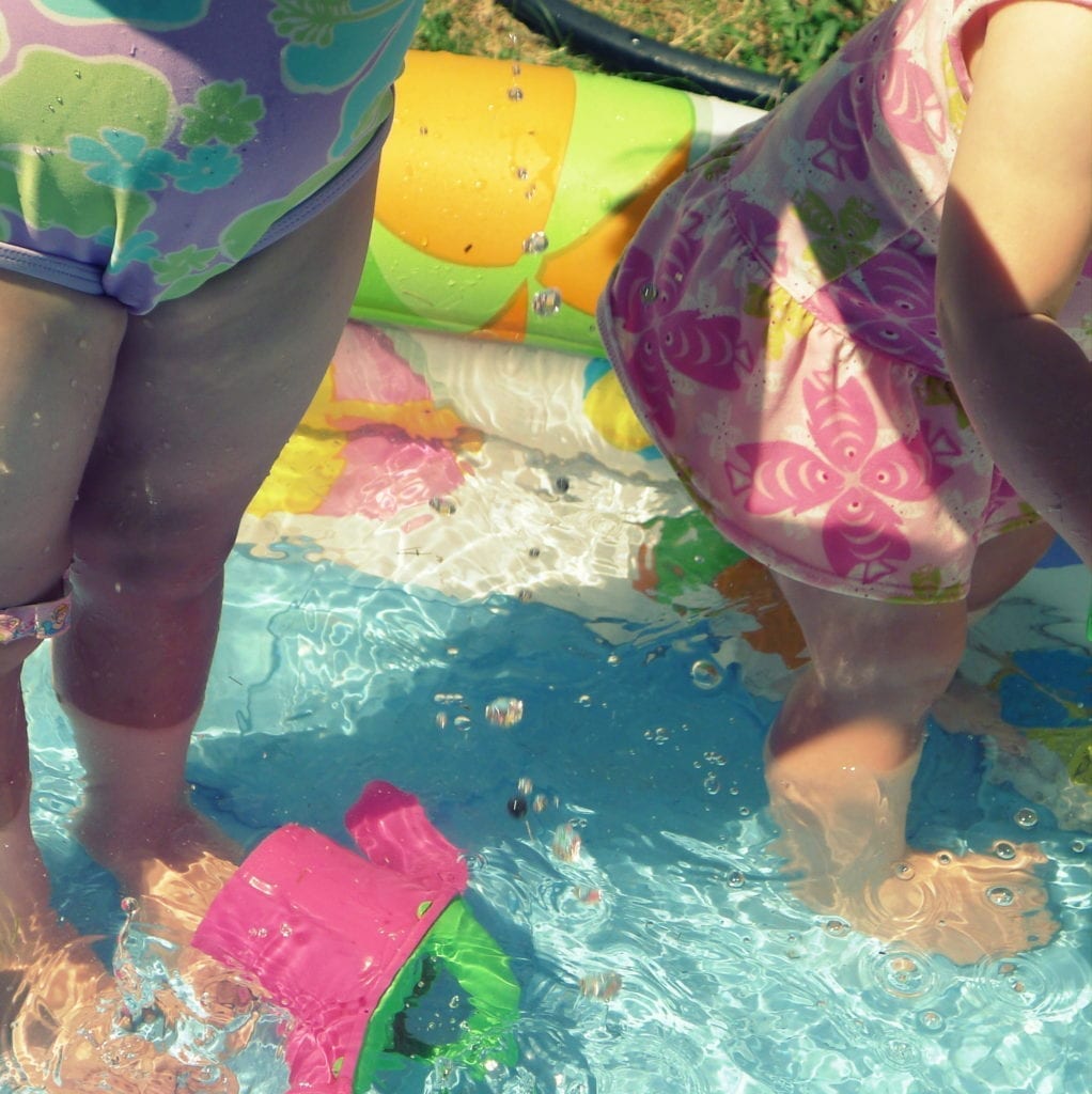 toddlers splashing in baby pool